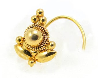 May include: A gold nose ring with a decorative design featuring a round center piece and small beads. The ring is marked "22K".