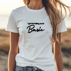 以下が含まれることがあります： 黒い文字で「I get the feeling you're Basic」と書かれた白いTシャツ。