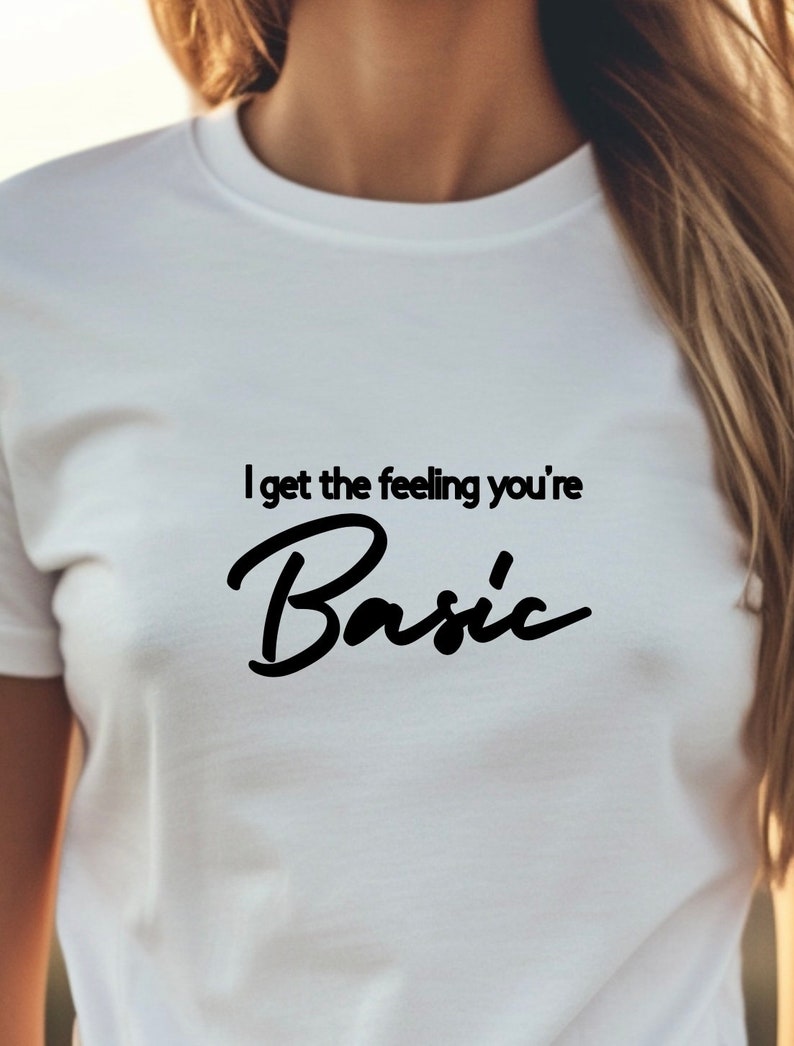 以下が含まれることがあります： 「I get the feeling you're Basic」という黒い文字が書かれた白いTシャツ。