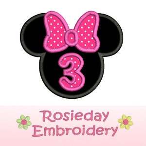 Pu&ograve; includere: Una testa di topo nera con un fiocco rosa a pois e il numero 3. Il numero 3 &egrave; delineato in rosa e pois bianchi. Il testo "Rosieday Embroidery" &egrave; sotto la testa del topo.