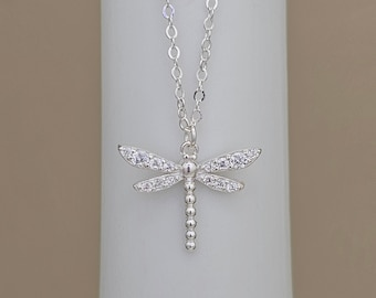 May include: A silver necklace with a dragonfly pendant. The dragonfly is adorned with clear cubic zirconia stones.