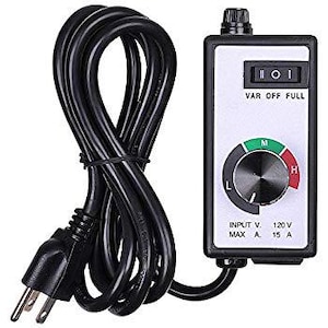 May include: A black and white electrical device with a dial, switch, and power cord. The dial has green and red indicators, and the text "VAR OFF FULL" is visible. The device is labeled "INPUT V. 120 V MAX A 15 A".