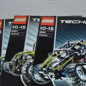 以下が含まれることがあります： LEGO テクニックセットの組み立て説明書4冊。モデル番号は8284。説明書は黒地に白文字で、緑と黒のオフロード車の画像が掲載されています。