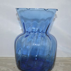May include: A blue glass vase with a ruffled top and a textured, wavy design.