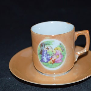 Kleine Teetasse und Untertasse / Orange / Lusterware / zwei Woment / Kind / abgebildet / hergestellt in Japan / Japan / Teetasse 2" Durchmesser / Untertasse 4,5"
