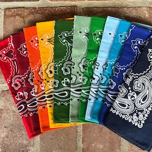 Puede incluir: Una colecci&oacute;n de diez pa&ntilde;uelos cuadrados dispuestos en forma de abanico, cada uno con un patr&oacute;n de cachemira blanco. Los colores incluyen rojo, granate, naranja, amarillo, verde oscuro, verde claro, verde brillante, azul claro, turquesa y azul oscuro.