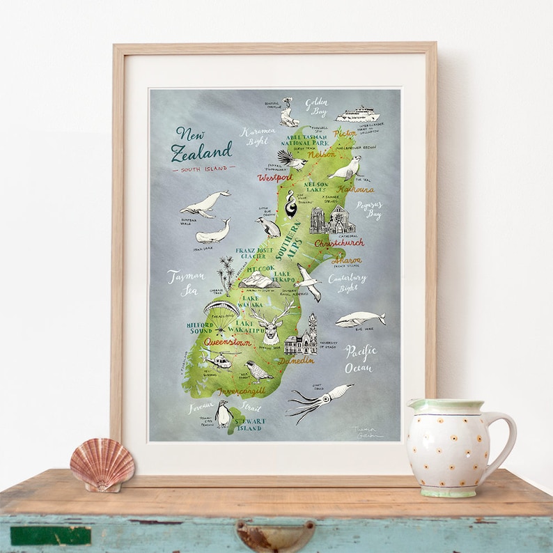 May include: A hand-drawn map of the South Island of New Zealand, featuring various landmarks and wildlife. The map is illustrated in a whimsical style with green and blue watercolor washes. The map includes text labels for locations such as Queenstown, Christchurch, and Franz Josef Glacier.