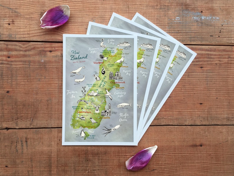 May include: A set of five illustrated postcards featuring a map of New Zealand with various animals and landmarks. The postcards are printed on a light blue background with a watercolor effect.