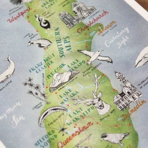 May include: A watercolor illustration of the South Island of New Zealand, featuring landmarks like Franz Josef Glacier, Mount Cook, Lake Wanaka, and Queenstown. The illustration includes a variety of animals, including whales, a deer, and a bird. The text "South Island" is written in the top left corner of the illustration.