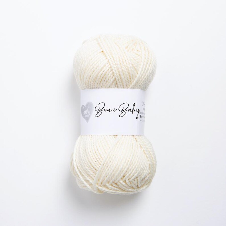 May include: A skein of white yarn labeled "Beau Baby" with a heart logo.