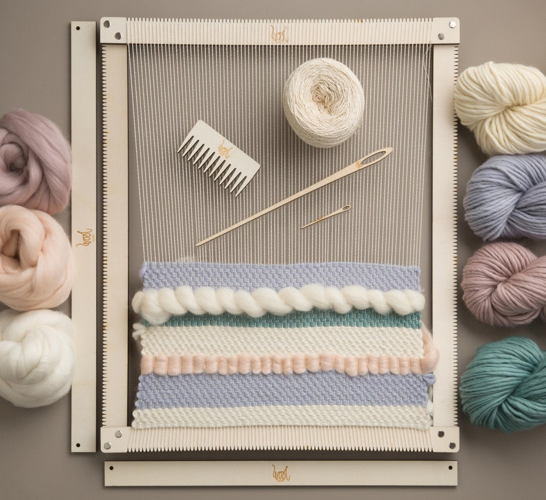 May include: A wooden loom with a partially completed tapestry featuring a variety of colors and textures. The loom is surrounded by balls of yarn in various shades of pink, white, blue, and green. The yarn is ready to be woven into the tapestry.