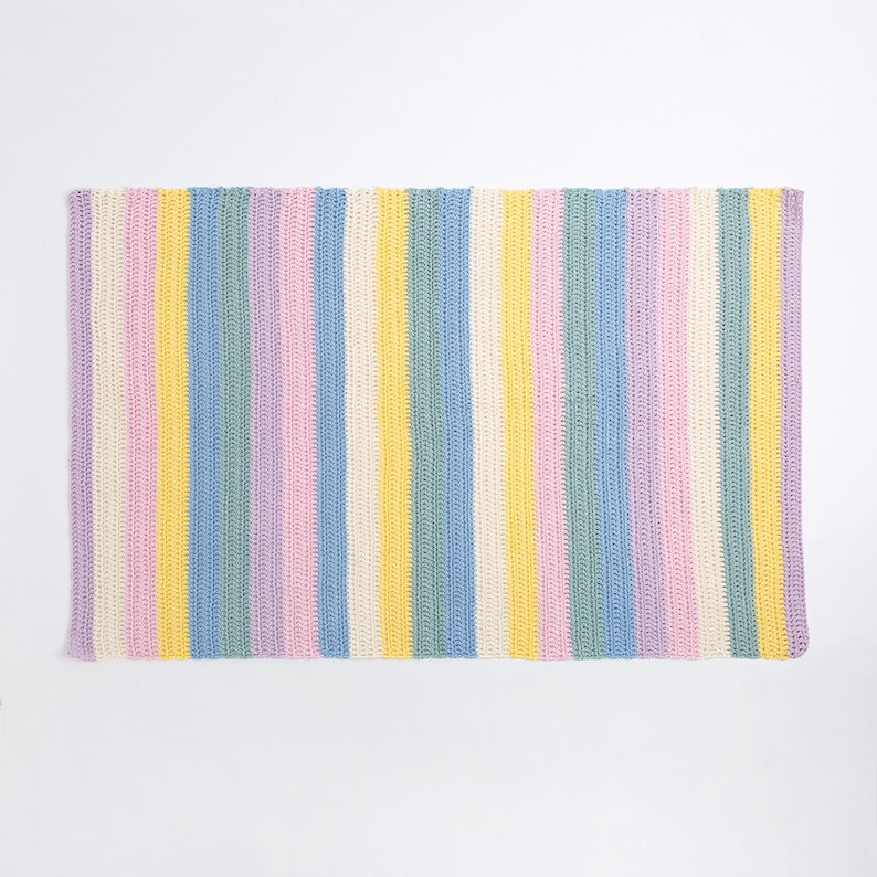 May include: A rectangular crochet blanket featuring a repeating vertical striped pattern in pastel colors including light purple, soft pink, bright yellow, sky blue, mint green, and cream white. The texture shows consistent yarn stitches.