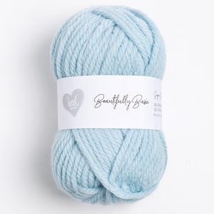 Puede incluir: Una madeja de hilo azul claro con una etiqueta blanca que dice "Beautifully Basic Super Soft 80% Premium Acrylic 20% Virgin Wool"