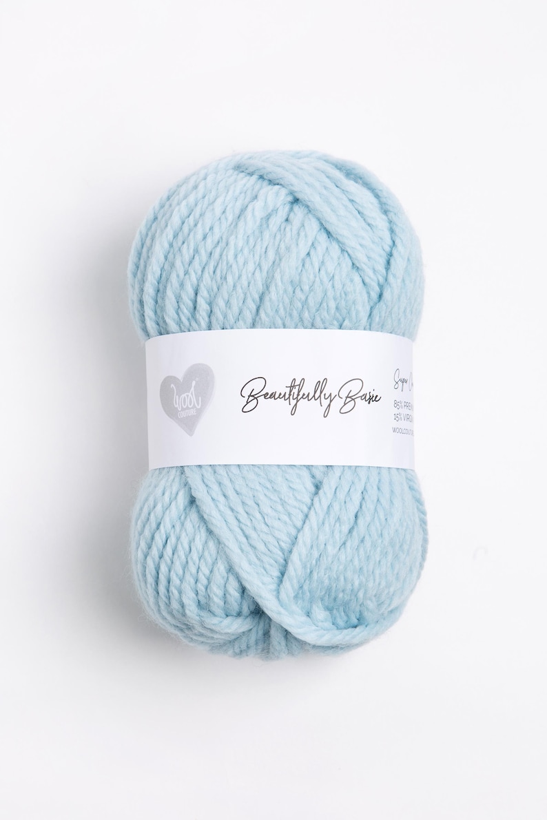 Puede incluir: Una madeja de hilo azul claro con una etiqueta blanca que dice "Beautifully Basic Super Soft 80% Premium Acrylic 20% Virgin Wool"