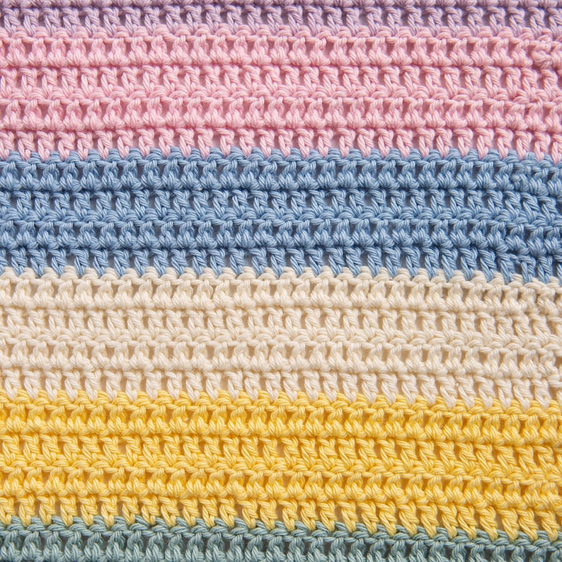 May include: A crocheted fabric featuring horizontal stripes in pastel colors. The pattern consists of repeating rows of double crochet stitches in light pink, soft blue, cream, bright yellow, and muted sage green, creating a textured surface.