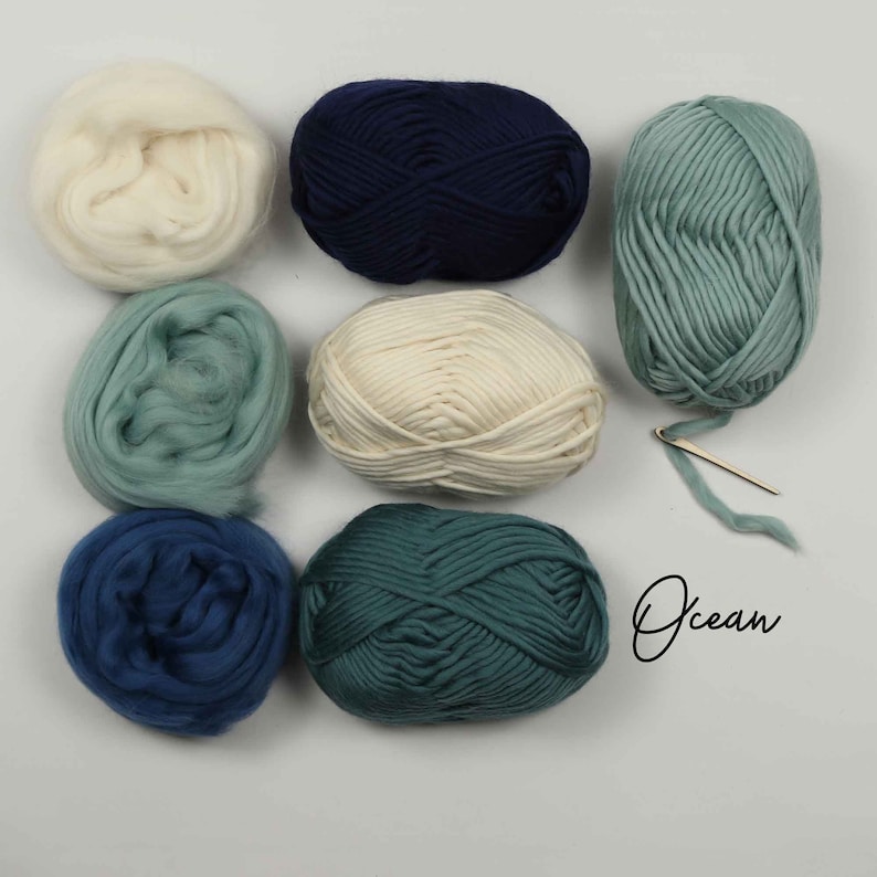 May include: Six balls of yarn in various shades of blue and green, including white and navy blue. The yarn is arranged in a square pattern on a white surface. The word "Ocean" is written in cursive on the right side of the image.
