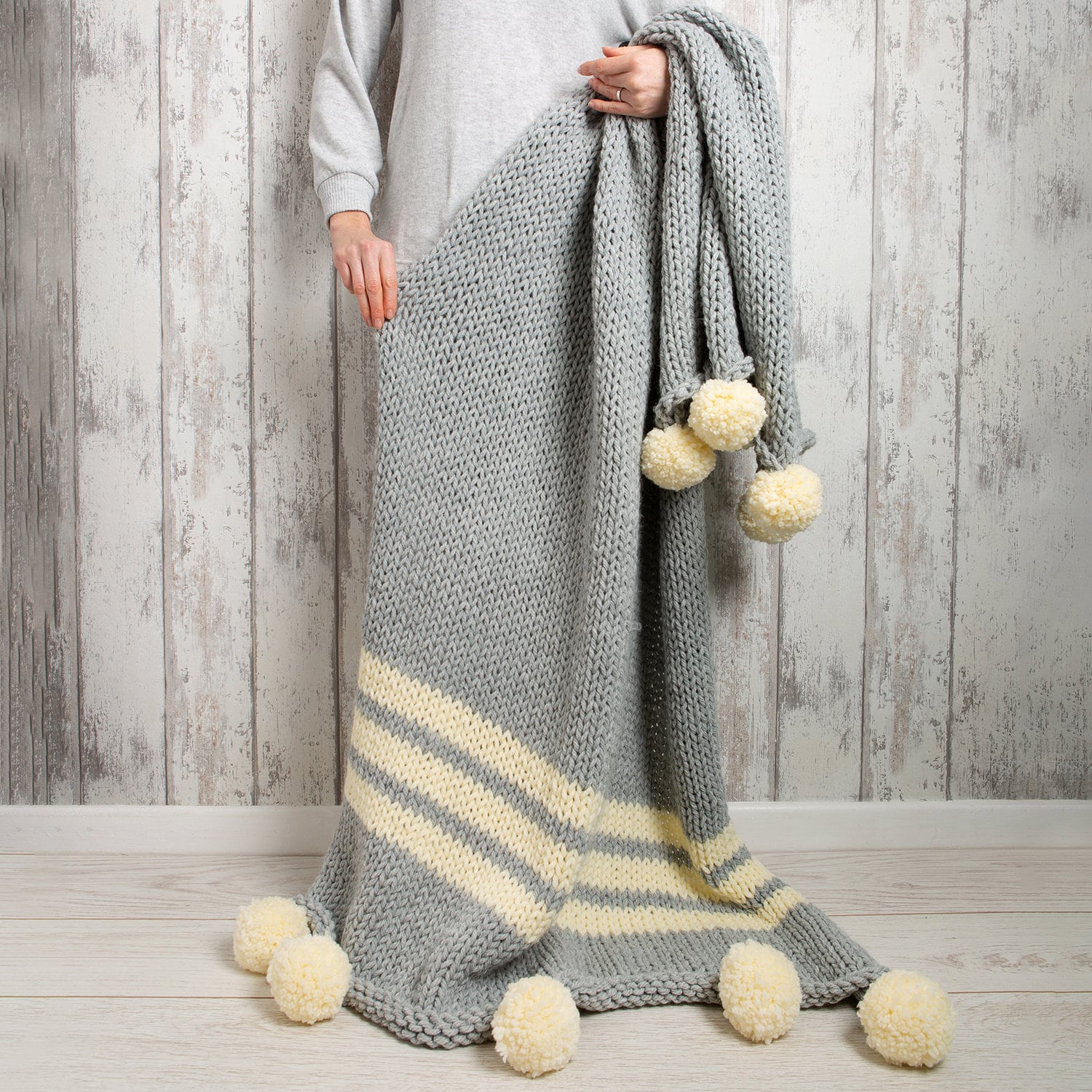 Grey knitted throw online with pom poms