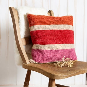 K&ouml;nnte beinhalten: Ein quadratisches Strickkissen mit horizontalen Streifen in den Farben Orange, Beige, Rot und Pink. Das Kissen hat eine strukturierte, handgestrickte Optik mit einem gleichm&auml;&szlig;igen Maschenbild &uuml;ber die gesamte Oberfl&auml;che des quadratischen Kissens.