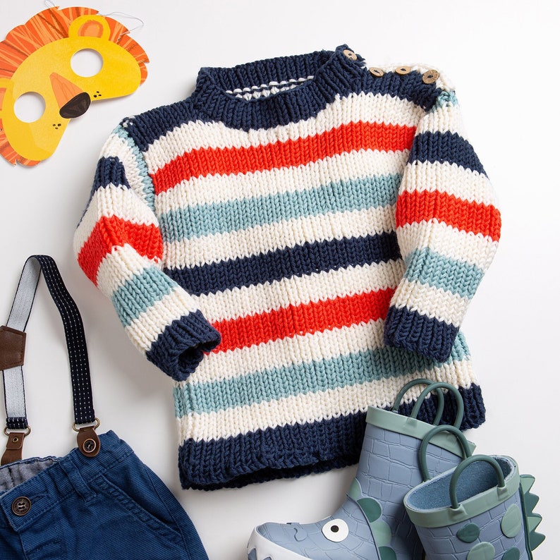 May include: A striped knitted jumper with red, blue and white stripes. The jumper has a round neckline and long sleeves.