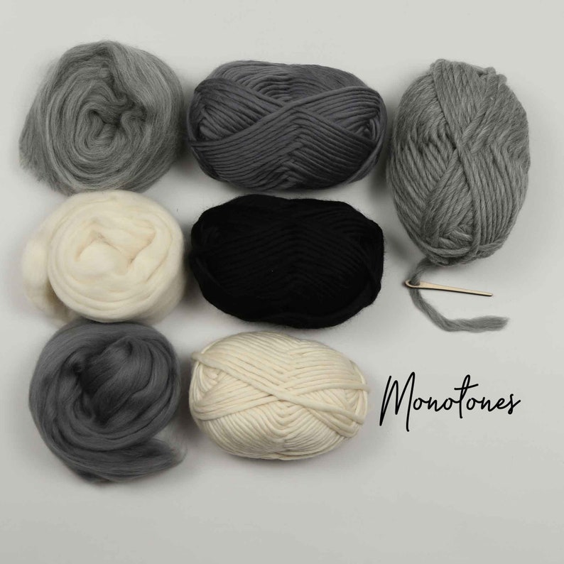 May include: A collection of six skeins of yarn in various shades of gray, white, and black. The yarn is arranged in a circle on a white surface. The word "Monotones" is written in black cursive below the yarn.