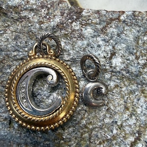 Könnte beinhalten: Eine weiße Keramik-Tasse mit schwarzem Henkel und dem Text "But First, Coffee" in schwarzer, fetter Schrift. Die Tasse steht auf einer weißen Oberfläche.