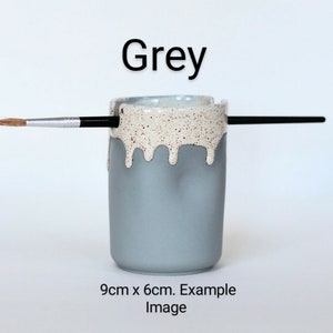 May include: Grey ceramic brush holder with a white speckled glaze and a drip effect. The holder is 9 cm x 6 cm. Example Image.