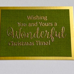 May include: A green card with a gold border and the text "Wishing you and yours a wonderful Christmas Time!" in gold lettering.