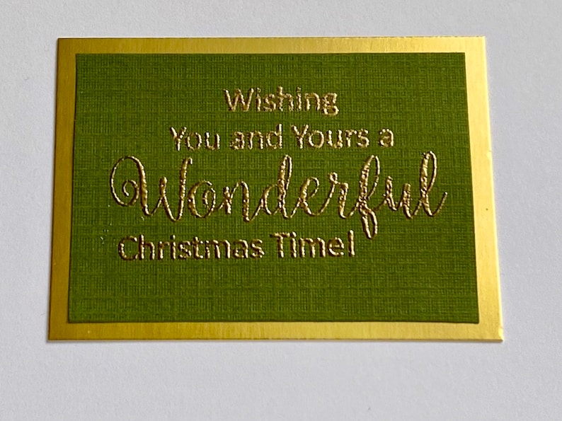 May include: A green card with a gold border and the text "Wishing you and yours a wonderful Christmas Time!" in gold lettering.