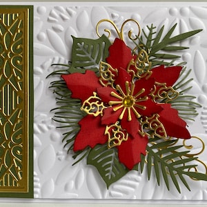 May include: A Christmas card with a red poinsettia flower, green leaves, and gold accents. The card has a white background with a textured pattern.