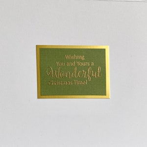 May include: A green card with a gold border and the text "Wishing You and Yours a Wonderful Christmas Time!" in gold lettering.