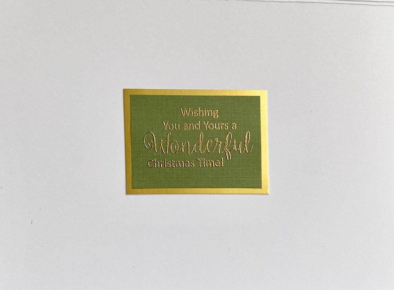 May include: A green card with a gold border and the text "Wishing You and Yours a Wonderful Christmas Time!" in gold lettering.