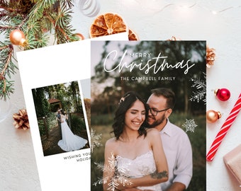May include: A Christmas card featuring a couple in a snowy setting. The card has the text "Merry Christmas" and "The Campbell Family" in white lettering.
