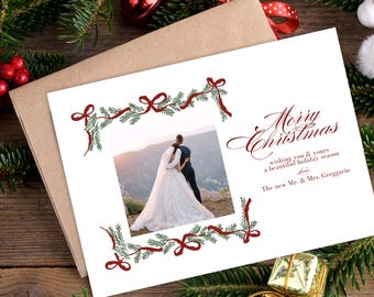 Op de afbeelding: Een witte kerstkaart met een rode en groene rand met een foto van een stel in trouwtenue. De tekst op de kaart luidt "Merry Christmas wishing you & yours a beautiful holiday season The new Mr. & Mrs. Greggario".
