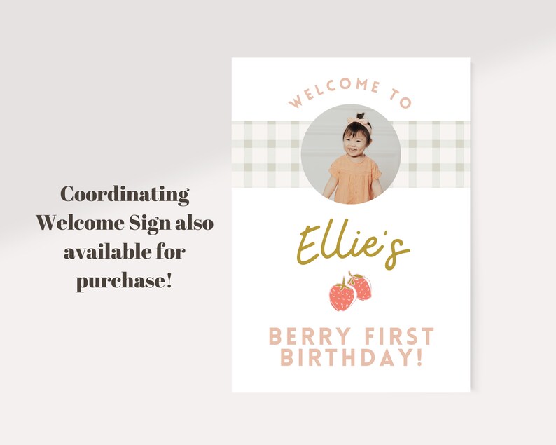 May include: A welcome sign for a first birthday party. The sign features a photo of a child, the name "Ellie's" in gold script, and the text "Berry First Birthday!" in pink. The sign also includes the text "Coordinating Welcome Sign also available for purchase!"