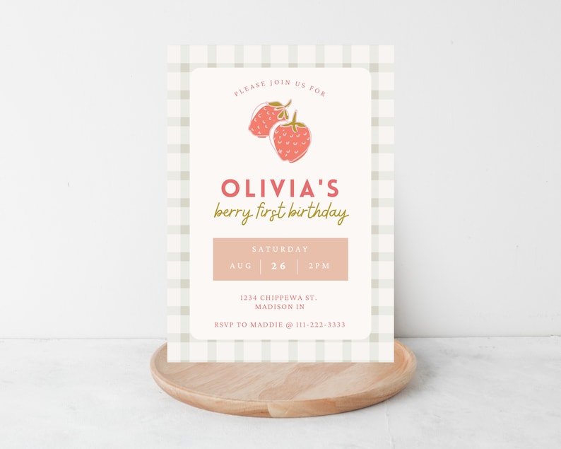 May include: A light-colored invitation with a strawberry illustration and the text "Olivia's berry first birthday." The invitation includes the date, time, and location. The background has a light green and white checkered pattern.