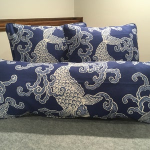 May include: Three decorative throw pillows with a blue background and white fish and cloud pattern. The pillows are made of a soft, textured fabric.