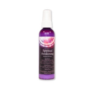 May include: A purple bottle with a white spray nozzle. The label reads "Spiritual Awakening Essential Oil Spray" and lists the ingredients, including a blend of pure essential oils, crystal essence, and spring water. The bottle is on a white background.
