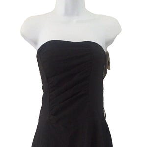 May include: A black strapless dress with a fitted bodice and a flowing skirt. The dress has a gathered detail at the waist.