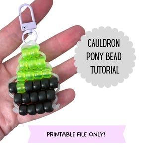 May include: A keychain made of neon green and black pony beads shaped like a cauldron, attached to a light purple lobster clasp. The image includes the text CAULDRON PONY BEAD TUTORIAL and PRINTABLE FILE ONLY! in a clear, sans-serif font.