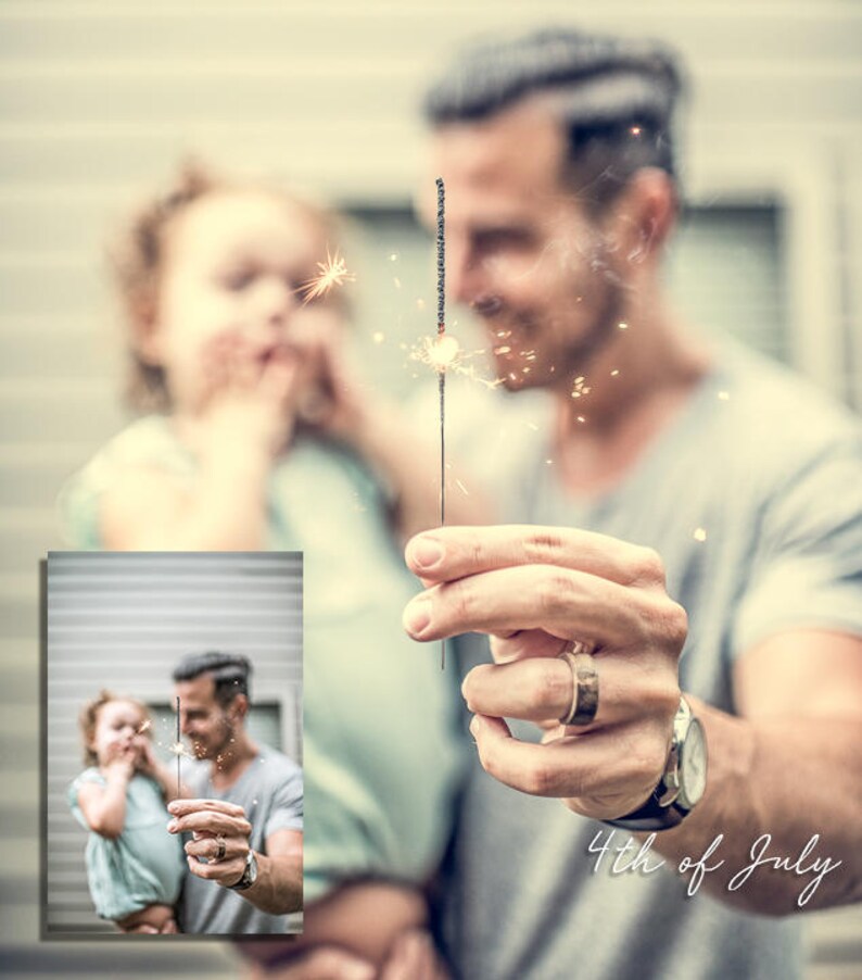May include: A father and daughter are holding sparklers and smiling. The father is wearing a gray shirt and the daughter is wearing a light blue shirt. The text "4th of July" is written in white cursive on the bottom right of the image.