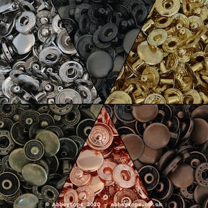 Puede incluir: Surtido de botones a presión metálicos en varios acabados, incluyendo plata, oro, cobre, bronce y negro. Los botones a presión están dispuestos en un patrón triangular.