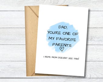 May include: A white greeting card with a light blue watercolor circle in the center. The text reads: DAD, YOU'RE ONE OF MY FAVORITE PARENTS with a heart symbol below. Below the circle, the text reads: I HOPE MOM DOESN'T SEE THIS! A brown envelope is behind the card.