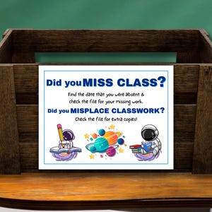 May include: A dark brown wooden crate featuring a white sign with blue text that reads: Did you MISS CLASS? Find the date that you were absent & check the file for your missing work. Did you MISPLACE CLASSWORK? Check the file for extra copies!