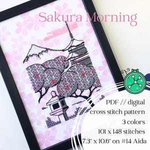 May include: A framed cross-stitch pattern titled "Sakura Morning." The design features a Japanese pagoda, trees with pink blossoms, and a traditional lantern. The pattern is 18.5cm x 26.9cm and uses 3 colours. The text "Sakura Morning" is at the top.