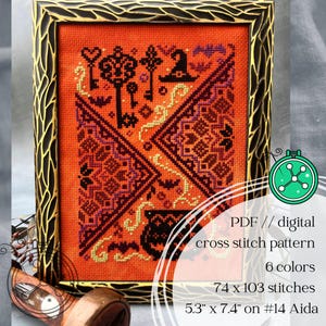 May include: A framed cross stitch pattern on orange fabric featuring black motifs including keys, a witch hat, bats, and a cauldron. The text reads: PDF // digital cross stitch pattern, 6 colors, 74 x 103 stitches, 5.3" x 7.4" on #14 Aida.