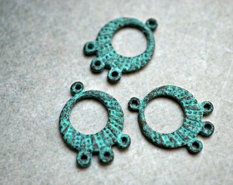 May include: Three turquoise metal rings with a textured surface and three small loops on each ring.