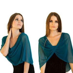 May include: Four women wearing teal blue sheer scarves in different styles. The scarves are draped over their shoulders and necks, and they are all wearing black tops underneath.