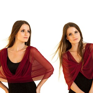 May include: A series of four images showcasing a woman wearing a sheer, burgundy-colored shawl over a black dress. The shawl is draped in different styles, highlighting its versatility and design. The background is plain white.