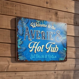 May include: A rectangular metal sign with a blue background featuring tropical leaf patterns and the white text "Welcome to the AVERIE'S Hot Tub Sit Back & Relax". The sign has a distressed, rusted-look border and is mounted on a wooden wall.