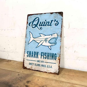 Letrero metálico de Quint's Shark Fishing: decoración de pared de película vintage inspirada en el cine oceánico clásico.